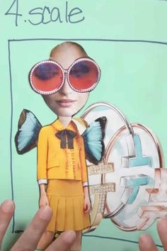 a person holding up a paper cut out of a girl with sunglasses and a butterfly on her head