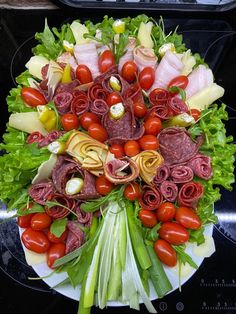 a platter filled with meat and vegetables on top of a stove