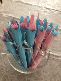 a glass bowl filled with blue and pink napkins