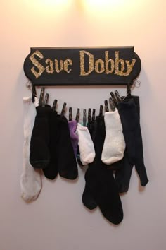 several pairs of socks hanging from a wooden sign that says save dobby on it