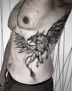 a man's chest with an eagle tattoo on his stomach and the bottom part of his body