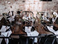 a wooden table topped with black and white place settings