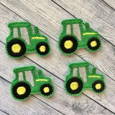 four embroidered tractors on a wooden surface