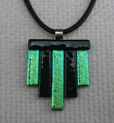 a black and green necklace with two rectangles hanging from it's side