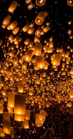 many lanterns are floating in the air at night