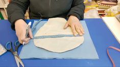 a person cutting fabric with scissors on a table