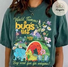 a woman wearing a green tshirt with the words world famous bugs life on it