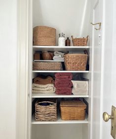 an organized closet with baskets and towels