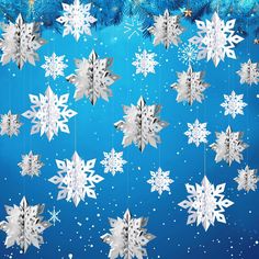 snowflakes hanging from strings on a blue background