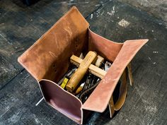 a brown leather bag filled with assorted items