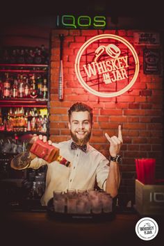 a man sitting at a bar making a peace sign