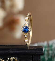 a close up of a gold ring with blue and white stones on it's side