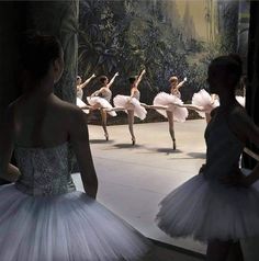 several ballerinas in white tutus are performing on stage