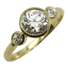 a gold ring with two diamonds on the top and one diamond in the middle,