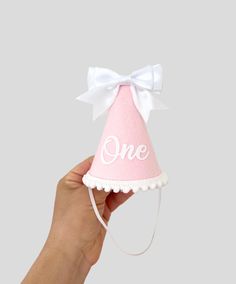 Bow party hat is made of - pink merino felt - white bow front and back - white iron on One - white pompom trim - elastic band Size is  H 12 cm W 8 cm IMPORTANT: Please do not give it to the baby or kids to play with. It can cause choking due to small particles or decorations. So please take that granted. THANK YOU Kindly note: Make sure your address is correct during checkout to avoid product loss If you want your party hat ASAP, choose "Rush my order" under quantity section in order to be made and shipped within 24 hour. Returns and Exchanges are accepted ✅Check policy With Love, Elina Playful White Hat For First Birthday, Coquette Party, Bow Party, 1st Birthday Cake Smash, Birthday Cake Smash, 1st Birthday Cake, White Bow, Party Hat, Girls Bows