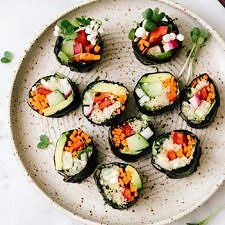 a white plate topped with cucumbers covered in toppings