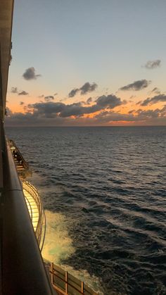 the sun is setting over the ocean as seen from a cruise ship's deck