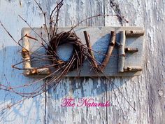 the word love is written on an old door with some twigs hanging from it's handle