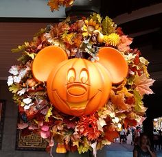 a mickey mouse pumpkin head hanging from the side of a building