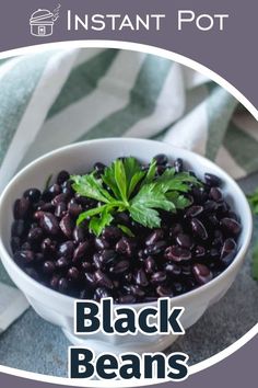 black beans in a white bowl with green leafy garnish on the side