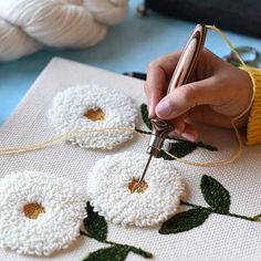 a person is working on some crochet flowers