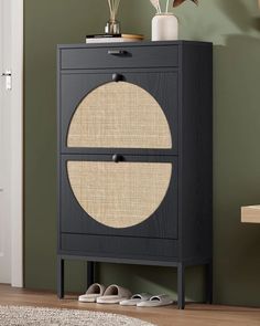 a black cabinet with two doors and some shoes on it in a living room next to a door