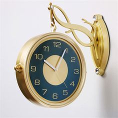 an alarm clock hanging on the wall next to a light fixture with two hands and no numbers