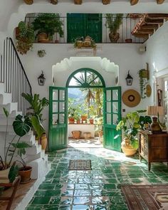 an entry way with green doors and potted plants