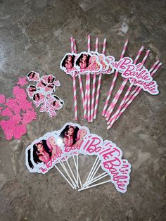 pink and white birthday candles with stickers on the top, surrounded by party straws