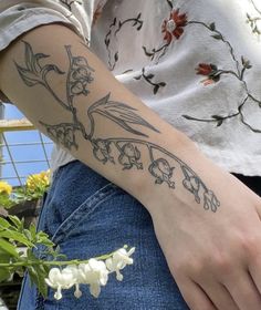 a woman with a flower tattoo on her arm