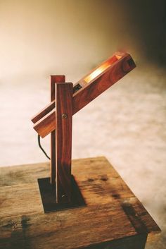 a wooden table lamp on top of a piece of wood in the shape of a cross