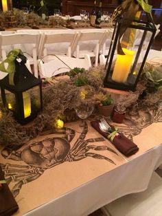 the table is set with two lanterns and place settings