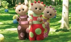 three stuffed animals standing next to each other in the grass