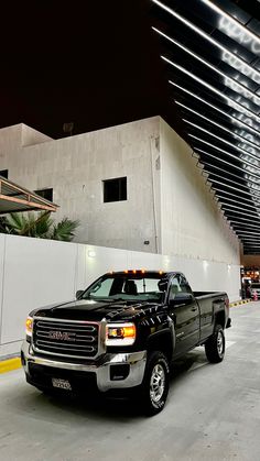 a black truck parked in front of a white building with lights on it's roof