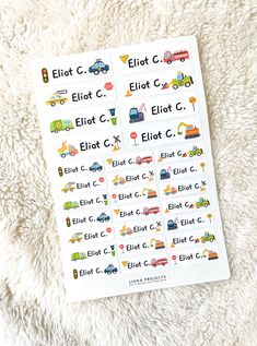 a close up of a sheet of stickers on a white blanket with cars and trucks