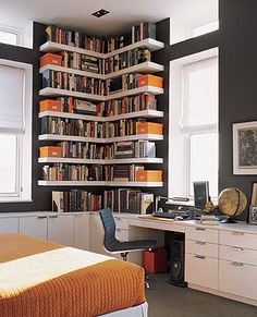 a bedroom with a bed, desk and bookshelf in it's corner