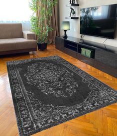 a living room with a large rug on the floor and a television in the corner