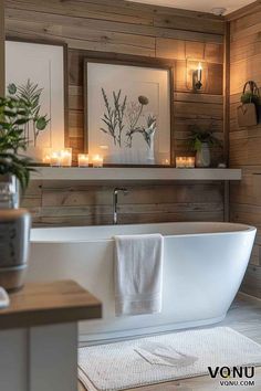 a white bath tub sitting in a bathroom next to a wooden wall with candles on it