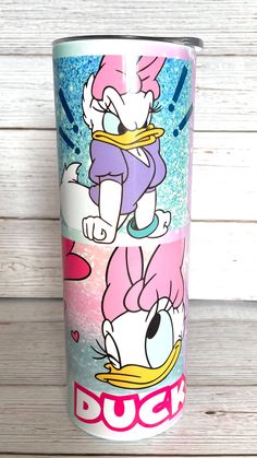 the tumbler cup has donald duck on it and is painted with pink, blue, and white colors