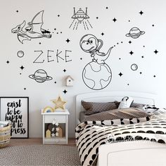 a bedroom with black and white wall decals in the shape of space shuttles