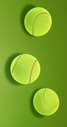 three tennis balls on a green surface