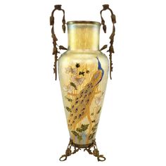 an ornate vase with a peacock painted on it's front and sides, sitting against a white background