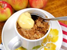 a bowl of oatmeal and some apples on a plate with a spoon