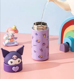 a person pouring water into a purple cup next to toys on a pink table with a rainbow in the background