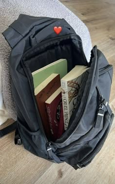 a backpack filled with books on top of a wooden floor