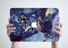 two hands holding up an apple ipad case with blue marble design on it and the cover is made out of plastic