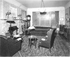 an old living room with couches, chairs and fireplace