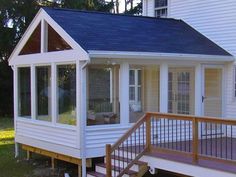 a small white house with a deck in front of it