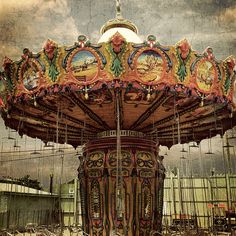 an old fashioned merry go round with horses on it