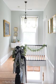 the stairs are decorated with black and white ribbons, greenery, and a bow